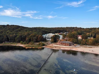 Aerial view of Lietzow on Rügen with beach, jetty, lagoon and forest, with the Lietzow Bay buildings in between